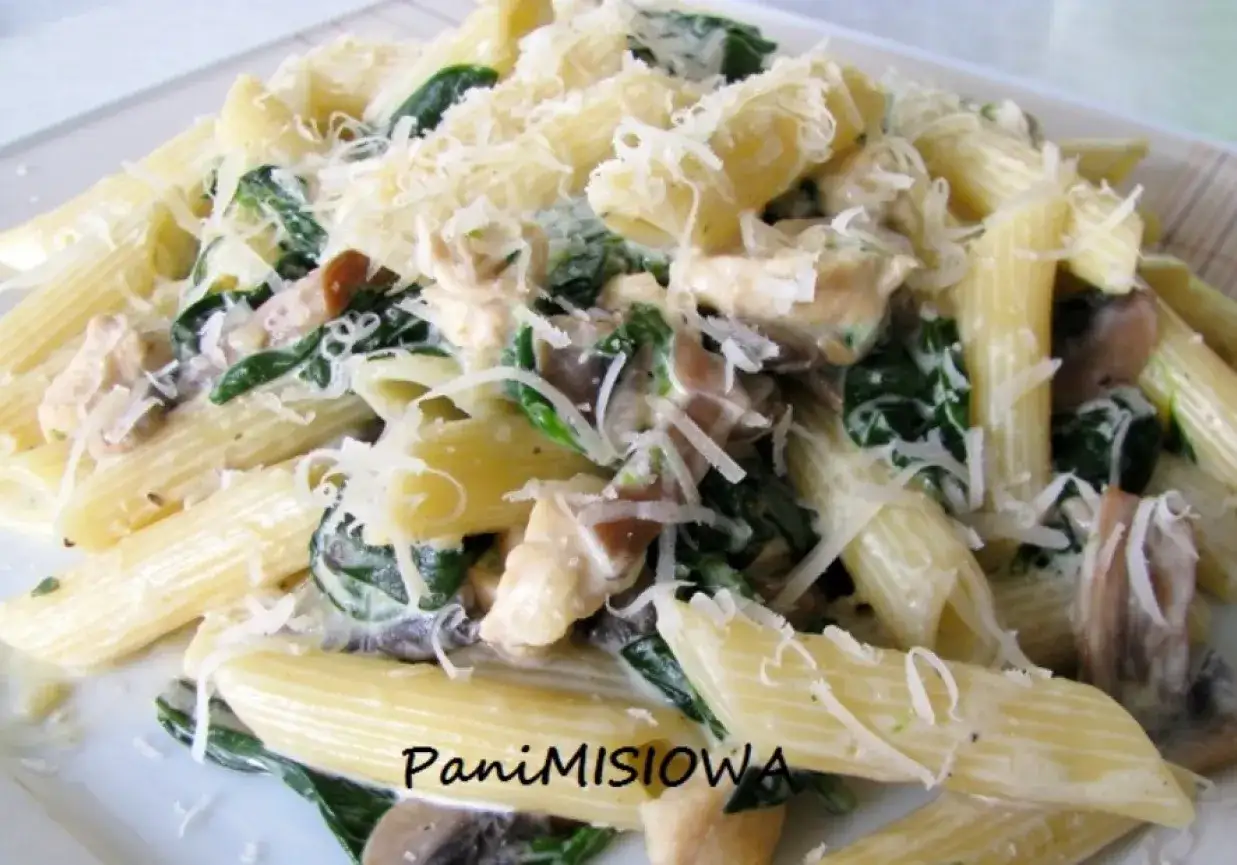 Penne z kurczakiem, pieczarkami i szpinakiem w kremowym sosie, posypane parmezanem. Pyszny makaron z pieczarkami i szpinakiem.