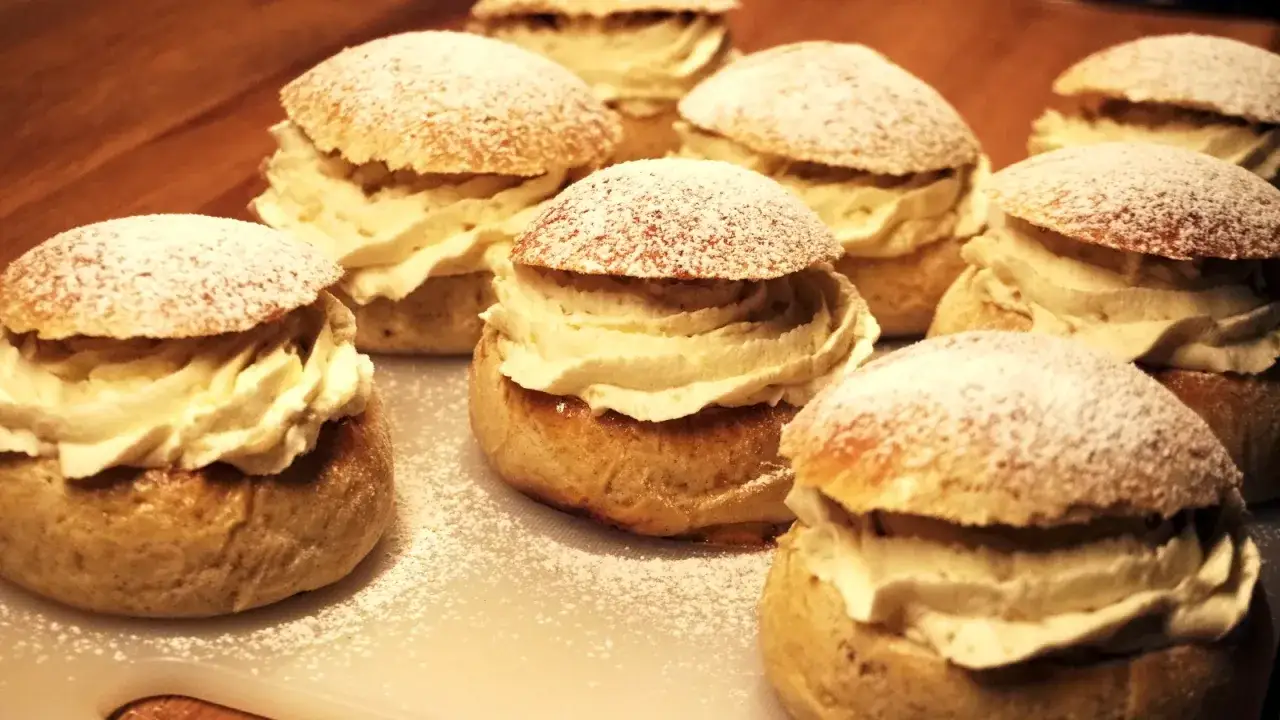Fettisdagen 2026 närmar sig med en härlig syn av semlor, generöst fyllda med grädde och pudrade med florsocker.