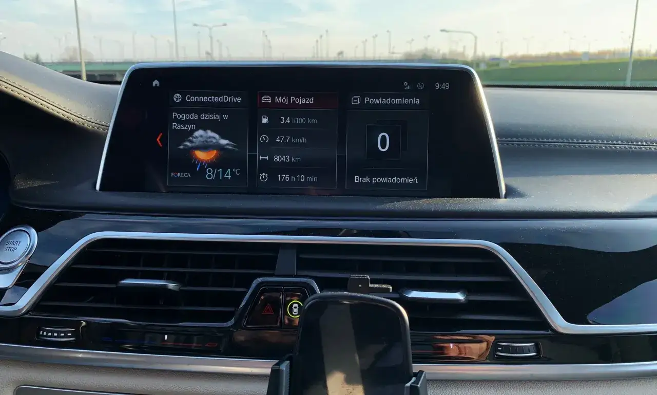 Wnętrze BMW 740d: ekran ConnectedDrive z pogodą 8/14°C, spalaniem 3.4l/100km i przebiegiem 8043km.