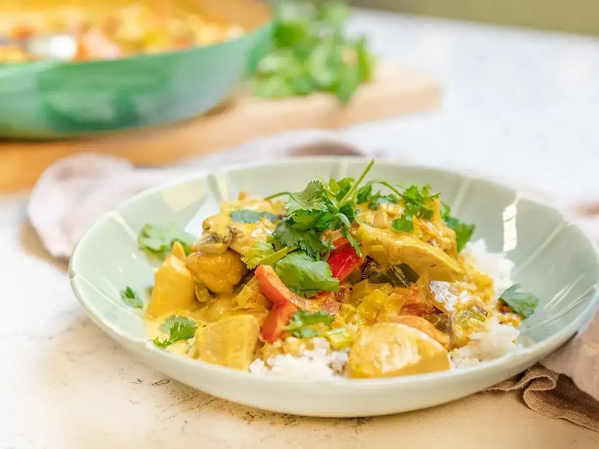 En krämig kycklingcurry med ris, toppad med färsk koriander. Ett enkelt och gott currysås recept för en smakrik middag.