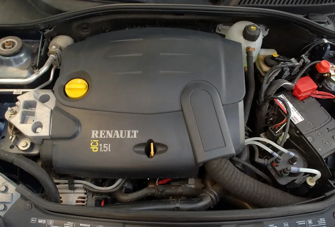 Silnik 1.5 dCi w Renault Thalia. Widoczny czarny plastikowy dekiel z logo Renault i żółty korek wlewu oleju.