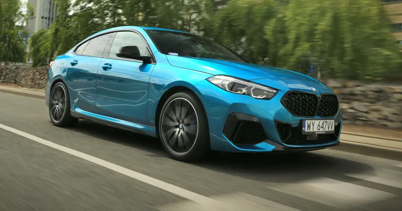 Błękitne BMW 235i sunie po drodze, uchwycone w ruchu.