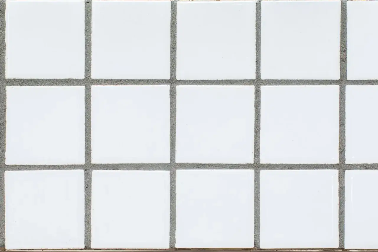 A grid of small white square tiles with gray grout. This image showcases simple grout options for a clean, classic look.