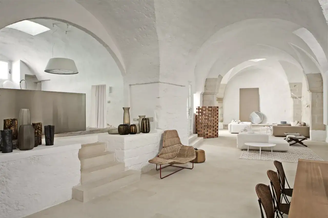 Interni moderni con volte a stella, arredi minimalisti e vasi decorativi.