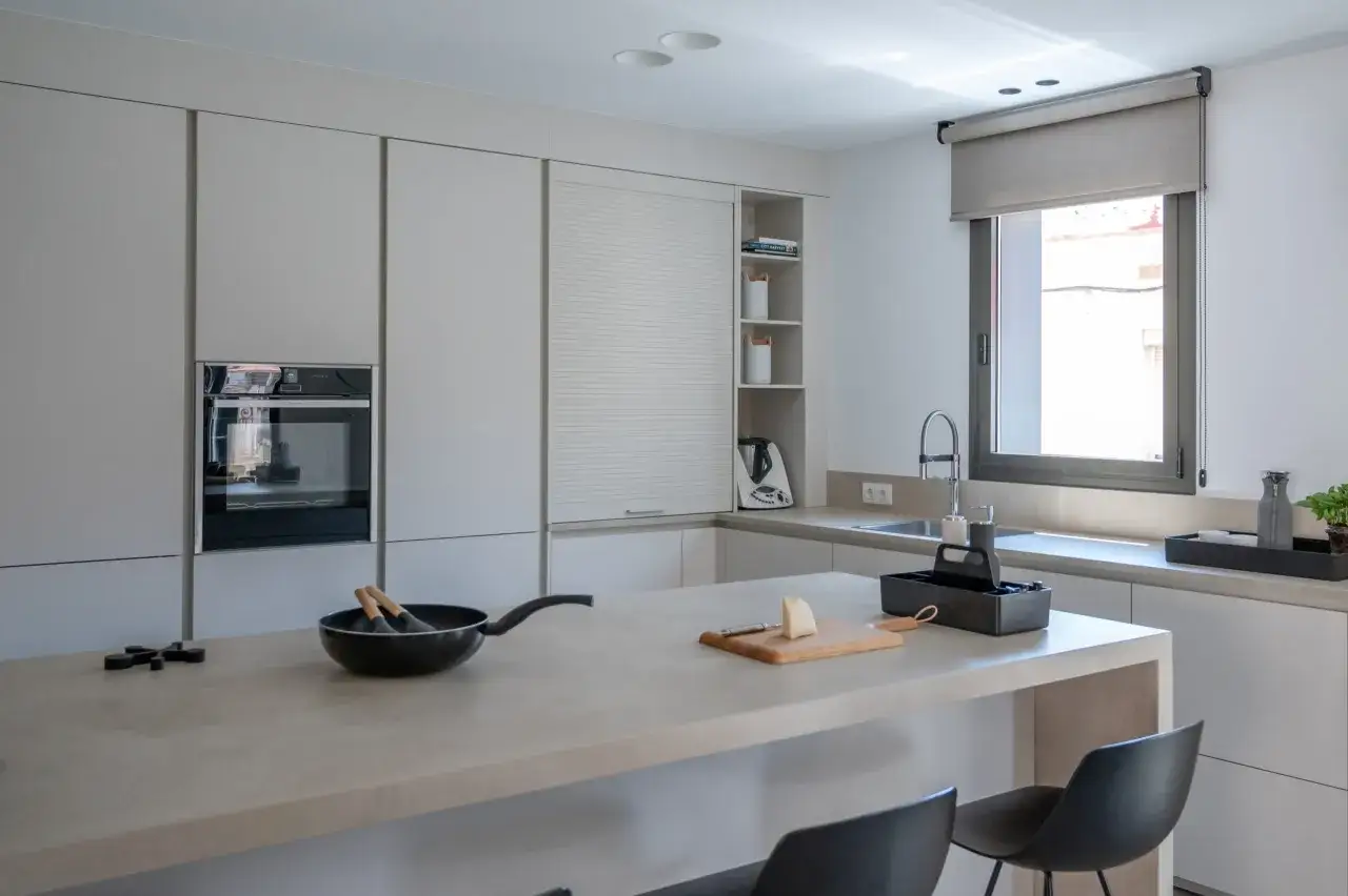 Moderna zona desayuno cocina con isla, sart&eacute;n y queso listo para preparar algo delicioso.