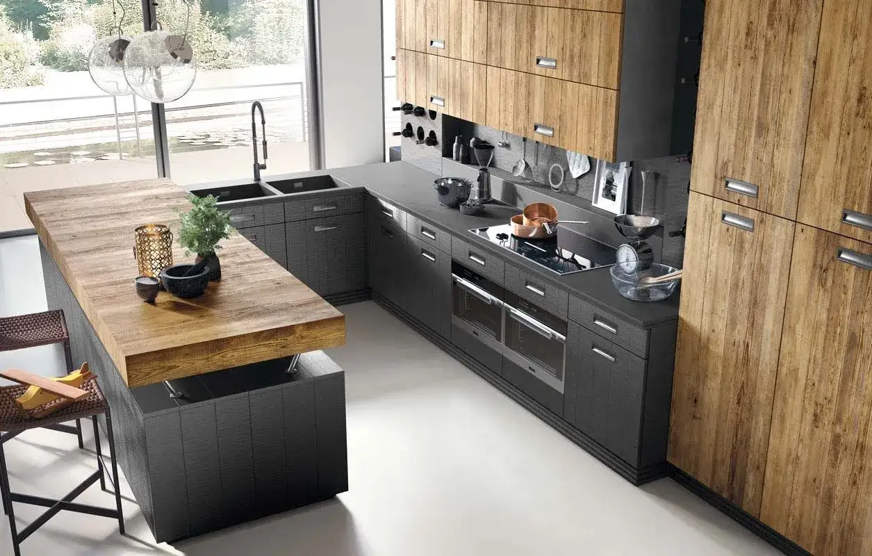 Moderna cocina equipada con isla de madera, gabinetes oscuros y electrodomésticos integrados.