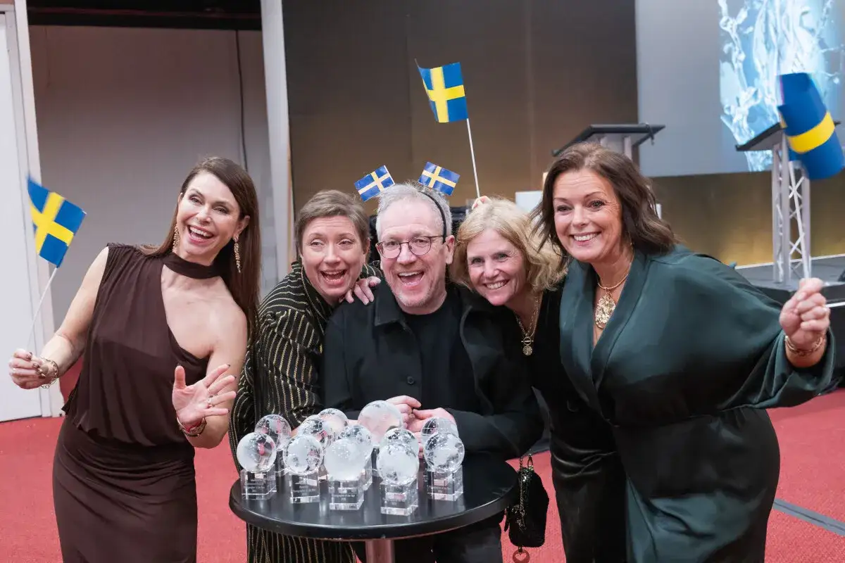 Glada vinnare med svenska flaggor och priser. En av dem &auml;r &aring;rets fotograf, firar stort!