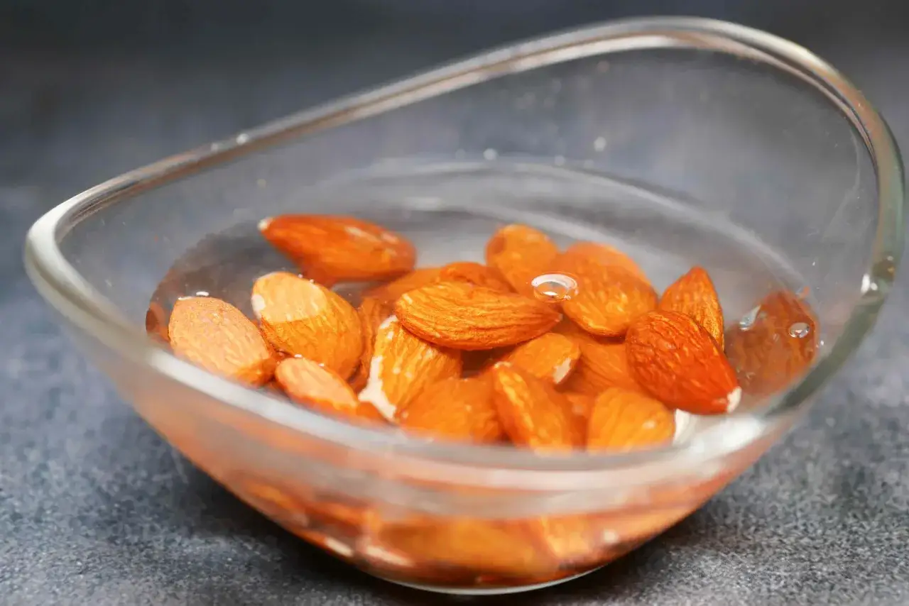 Amandes dans un bol d'eau, pr&ecirc;tes &agrave; &ecirc;tre tremp&eacute;es. Savoir pourquoi faire tremper les amandes am&eacute;liore leur digestibilit&eacute; et leur saveur.