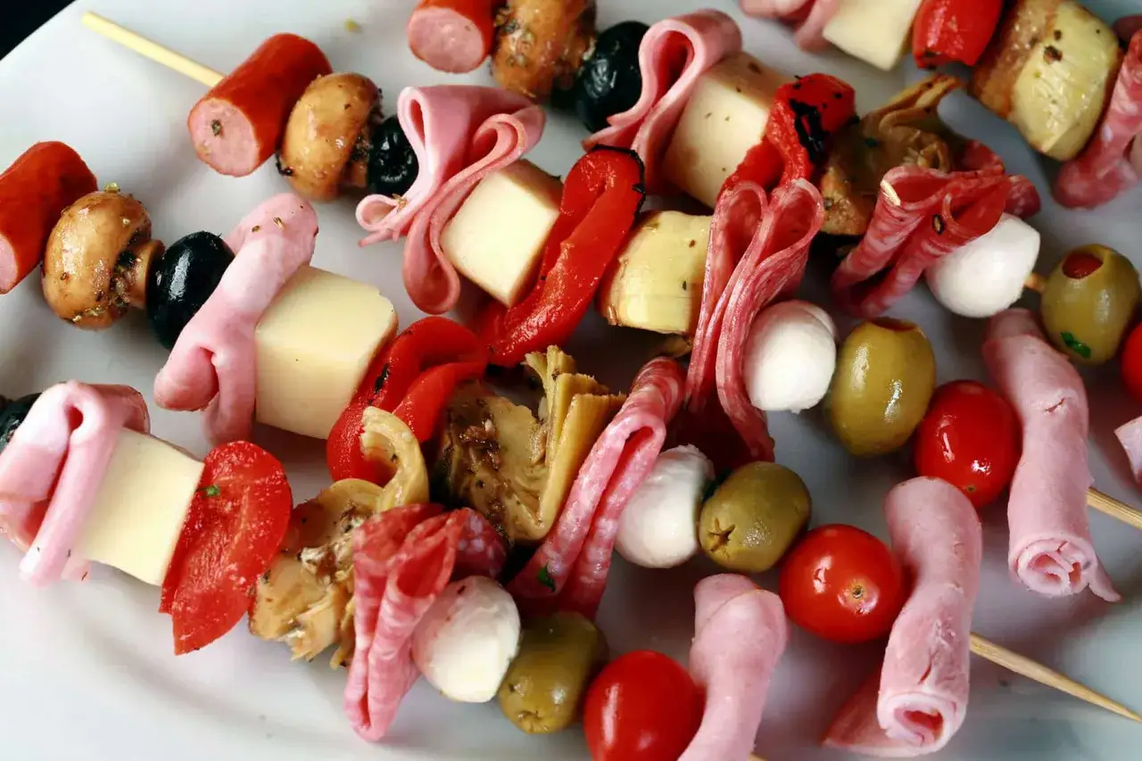 Des brochettes ap&eacute;ro color&eacute;es avec saucisses, champignons, olives, poivrons grill&eacute;s, jambon, salami, tomates cerises et billes de mozzarella.