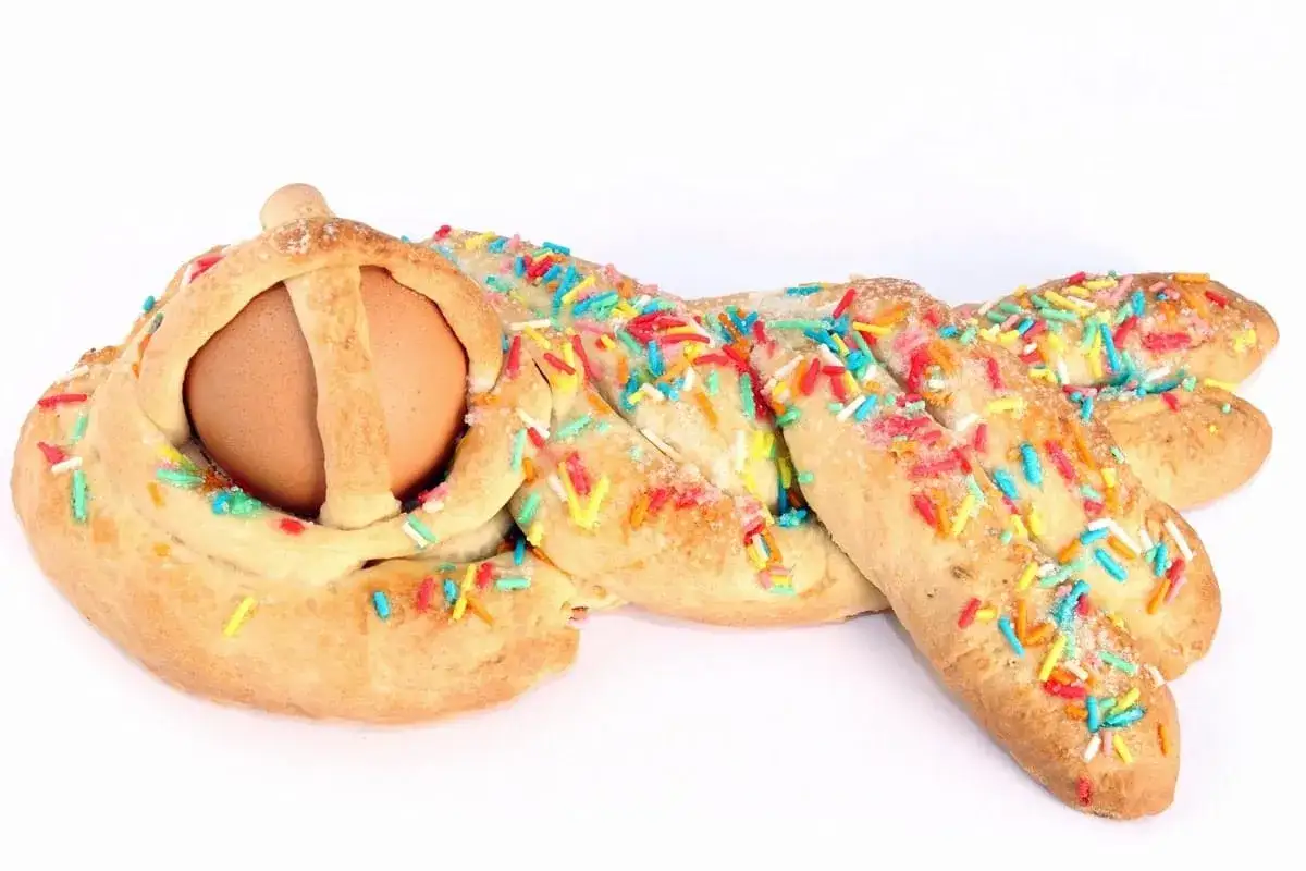 Dolci intrecci di pasta frolla con uovo sodo e zuccherini colorati, tipici dessert pasquali.