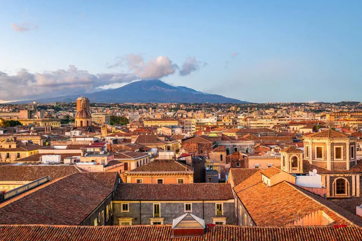Vista aerea di Catania con l'Etna sullo sfondo. Un panorama che ispira tante cose da fare a Catania, tra storia e natura.