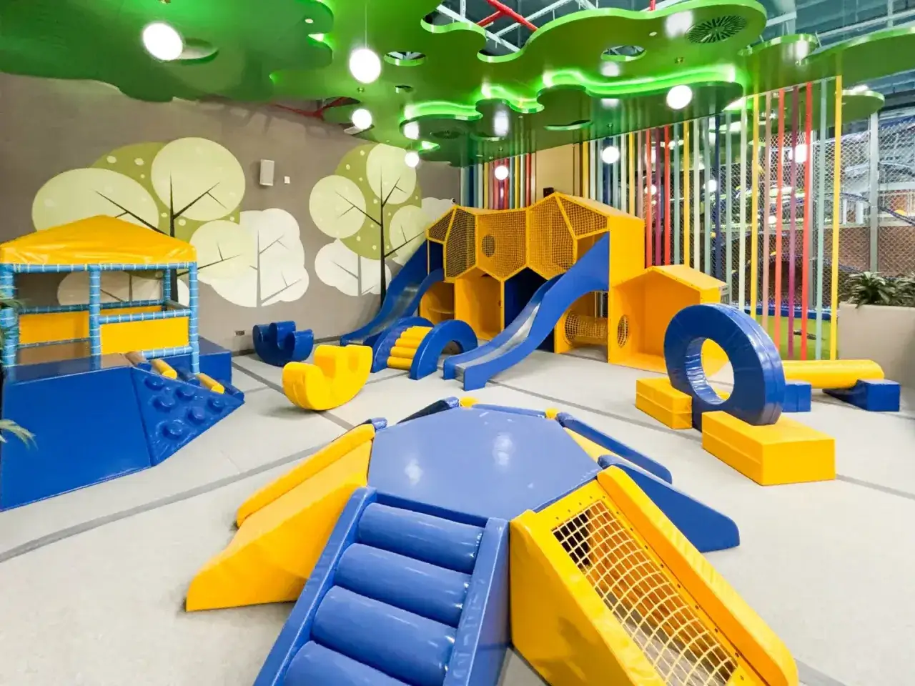 Kolorowy park dla dzieci z miękkimi zjeżdżalniami, tunelami i labiryntami. Idealne miejsce do zabawy i rozwoju.