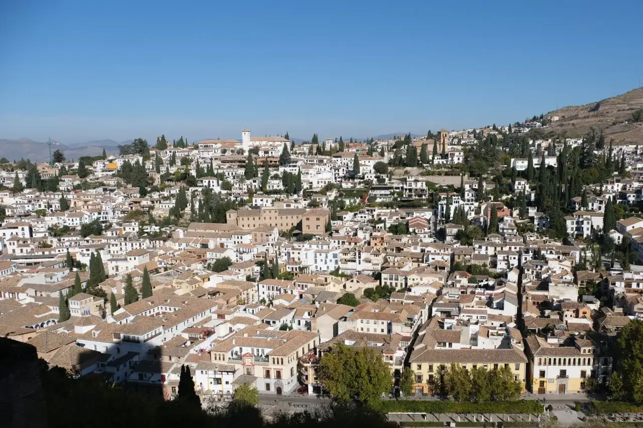 Vue panoramique de Grenade, ville aux toits de tuiles ocres et aux maisons blanches, un endroit idéal pour visiter Grenade.