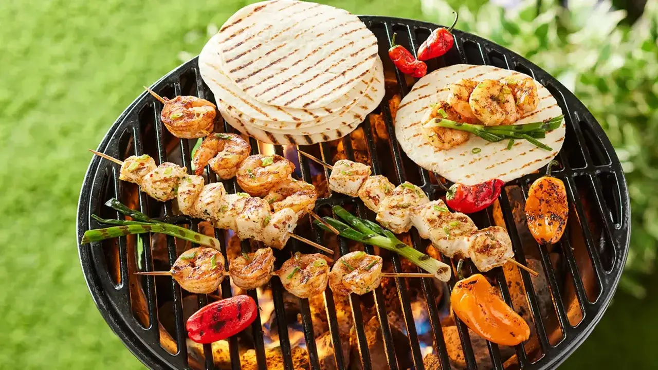 Brochettes de crevettes et de poulet grillées, accompagnées de tortillas et de poivrons colorés. Un délice de tapas barbecue !