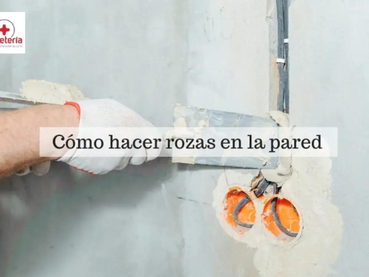 Mano con guante blanco aplica yeso para tapar rozas en pared, cerca de cajas de registro el&eacute;ctricas.