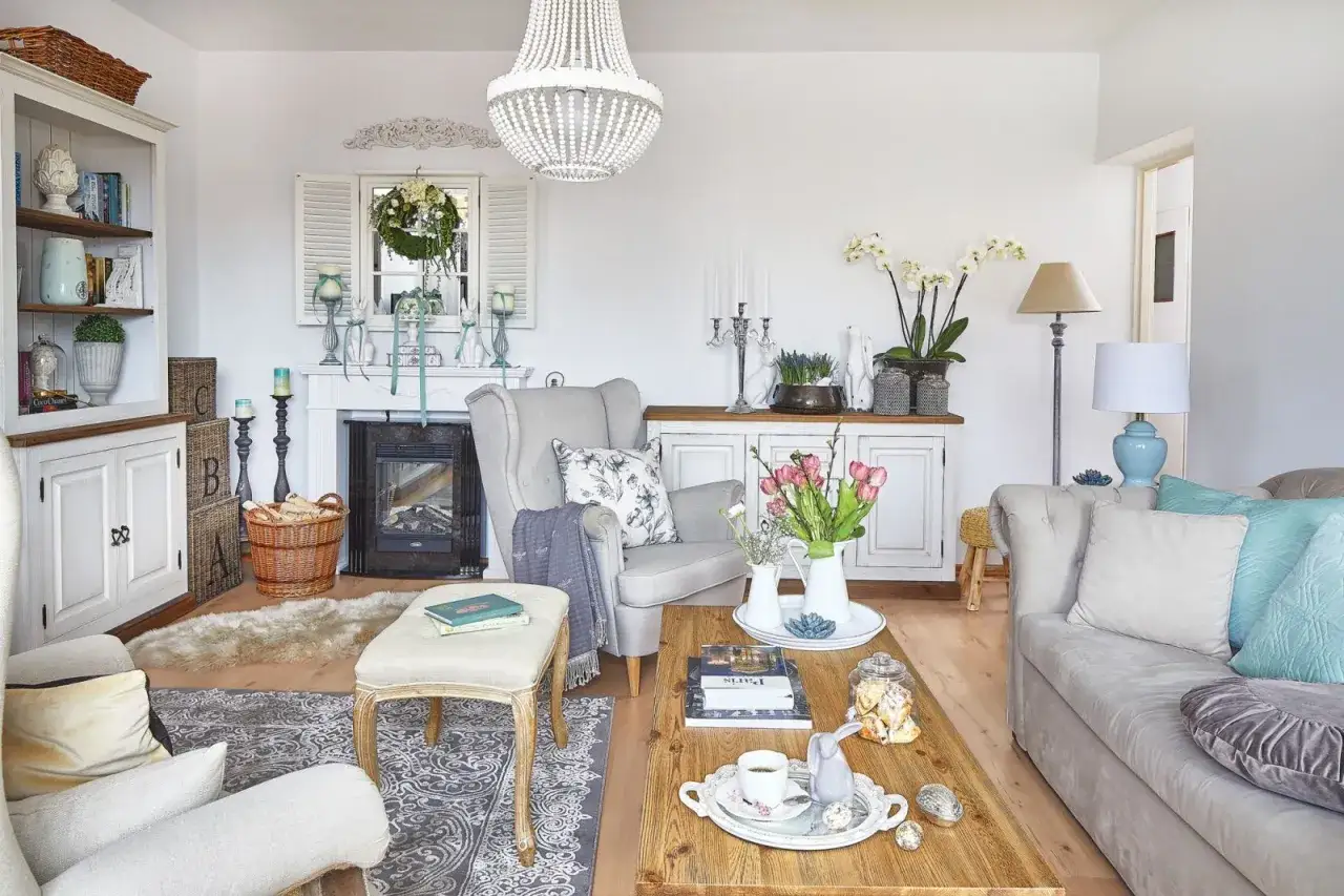 Przytulny salon w stylu prowansalskim. Jasne meble, kominek, bukiet tulipan&oacute;w i wielkanocne dekoracje tworzą sielski klimat.