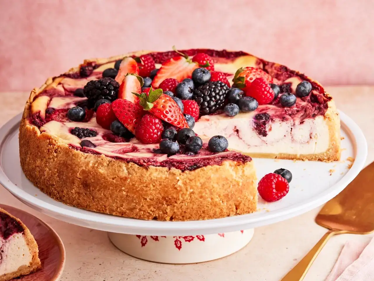 Ein saftiger american cheesecake, üppig belegt mit frischen Beeren wie Erdbeeren, Blaubeeren und Himbeeren.