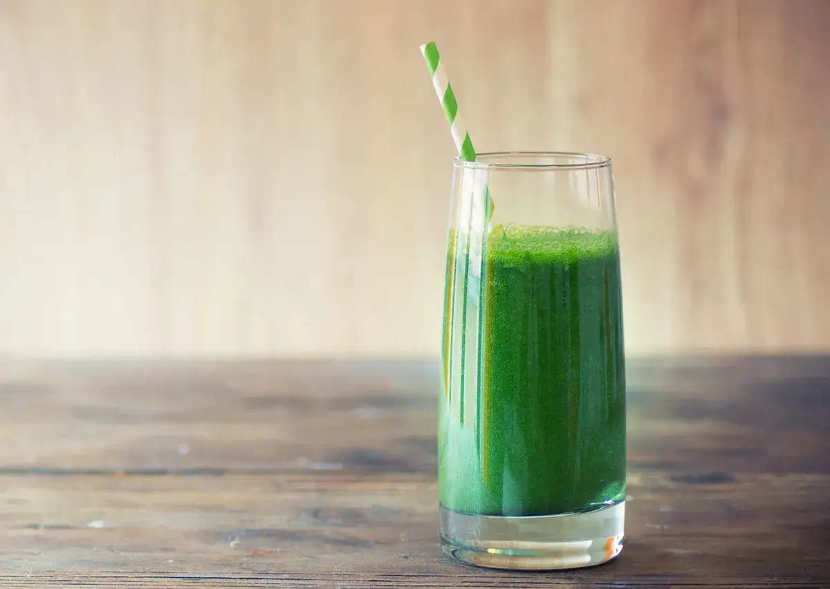 Gr&uuml;ner Smoothie im Glas mit Strohhalm. Erste saftkur erfahrungen sind positiv, erfrischend und belebend.