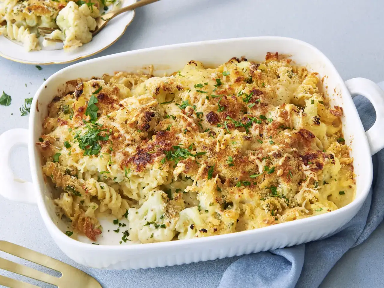 Herzhaftes Blumenkohl Mac and Cheese, überbacken mit knuspriger Kruste und frischer Petersilie. Ein Genuss für die ganze Familie!