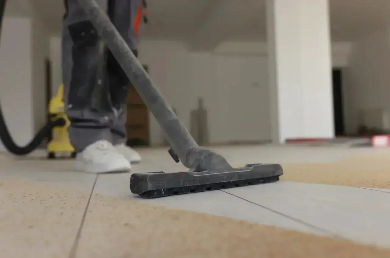 Aspirateur en action pour comment nettoyer carrelage apr&egrave;s chantier. La poussi&egrave;re de chantier est aspir&eacute;e du sol carrel&eacute;.