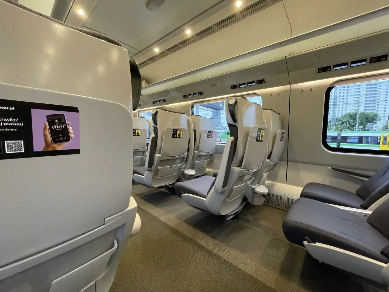 Wnętrze pociągu Intercity. Fotele w 1 klasie są szare, w 2 klasie ciemniejsze.