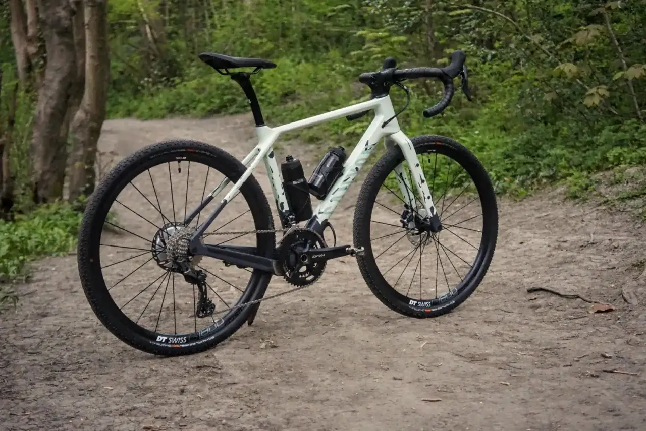 Jasny rower crossowy z czarnymi detalami, gotowy na leśne ścieżki. Czy to rower crossowy czy MTB?