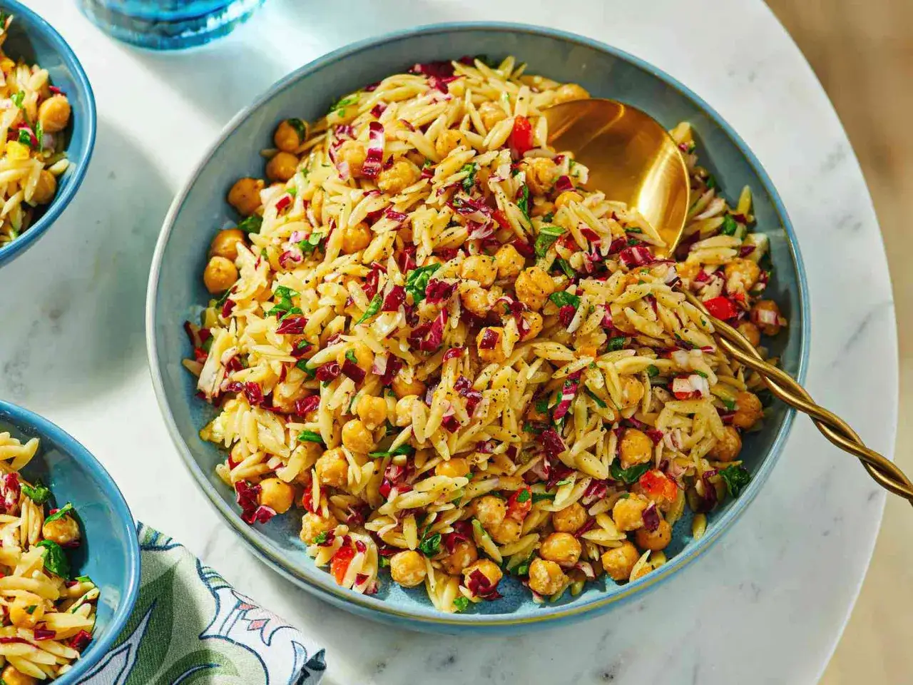 En stor skål med en härlig orzopasta-sallad med kikärtor, rödlök och persilja. Ett perfekt risoni recept för sommaren.
