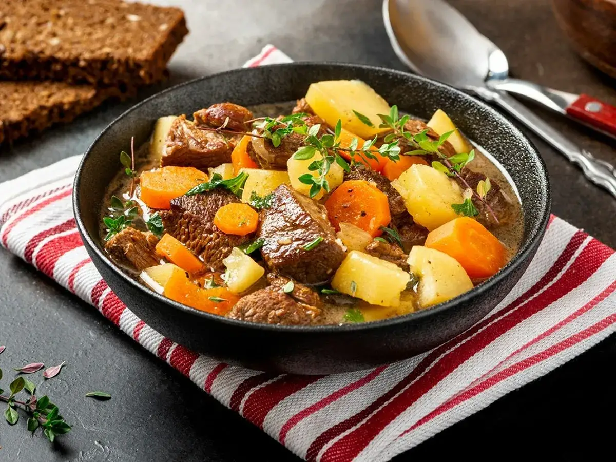 Un réconfortant ragoût d'agneau façon grand-mère, avec des morceaux tendres, des carottes et des pommes de terre, garni de thym frais.