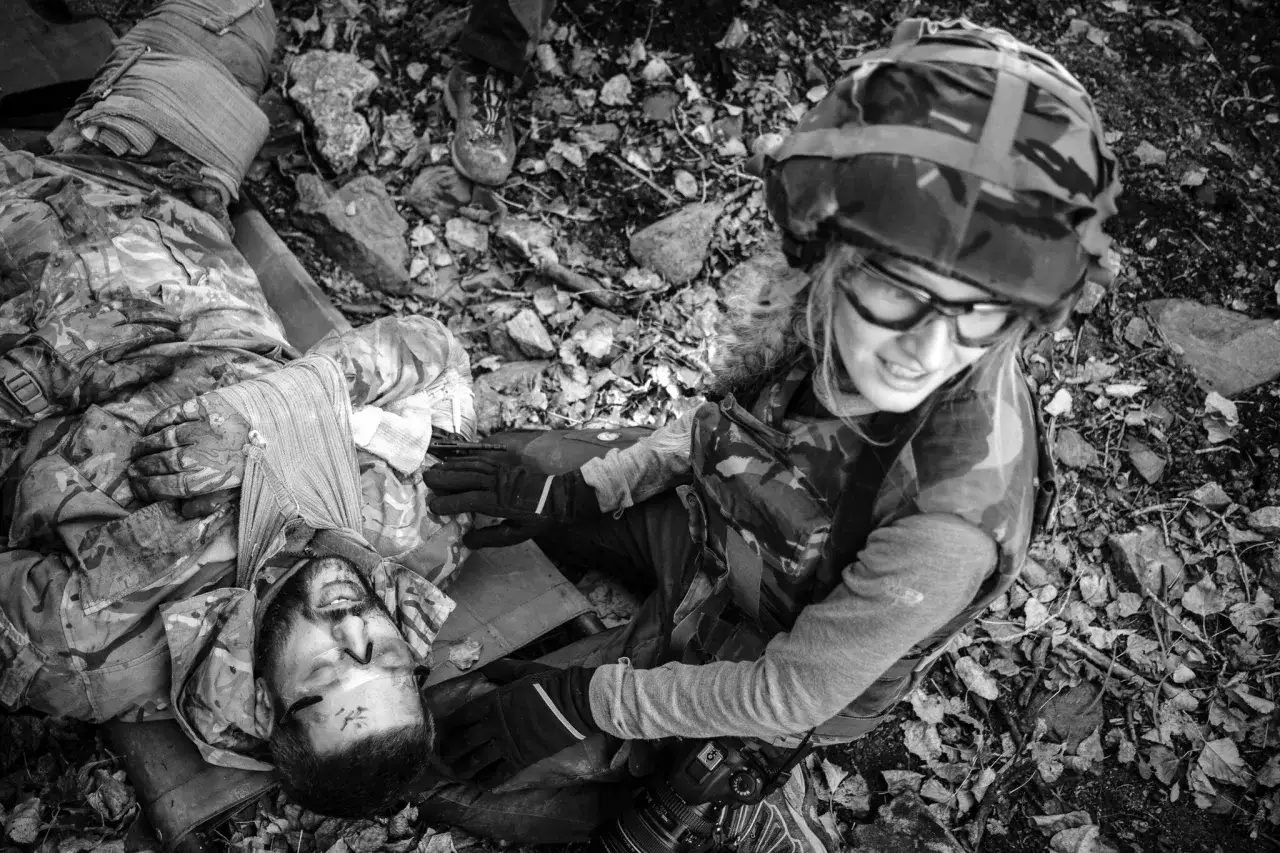 Wstrząsająca fotografia wojenna: ranny żołnierz opatrywany przez koleżankę, która trzyma aparat, by uwiecznić ten moment.