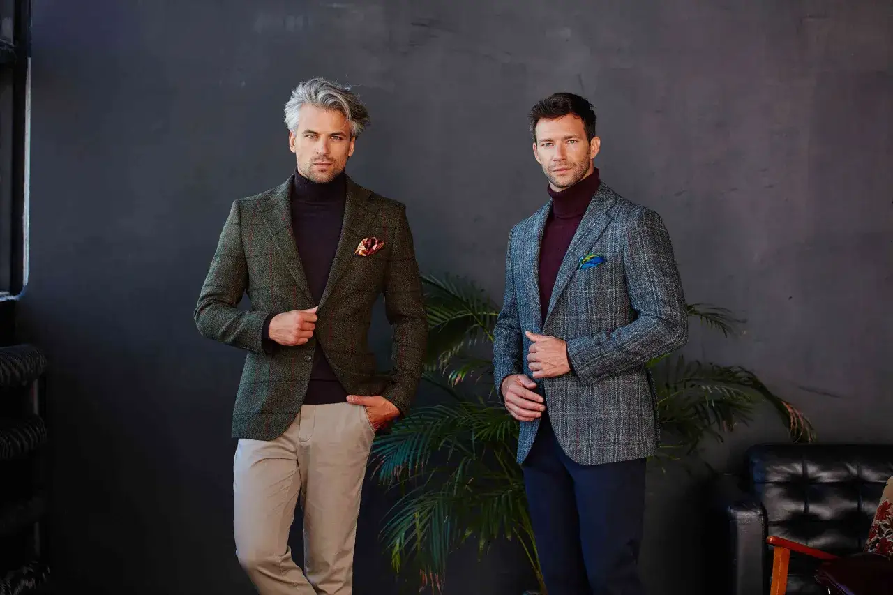 Eleganccy mężczyźni w marynarkach i golfach. Inspiracja, jak się ubrać do teatru muzycznego, by wyglądać stylowo i z klasą.