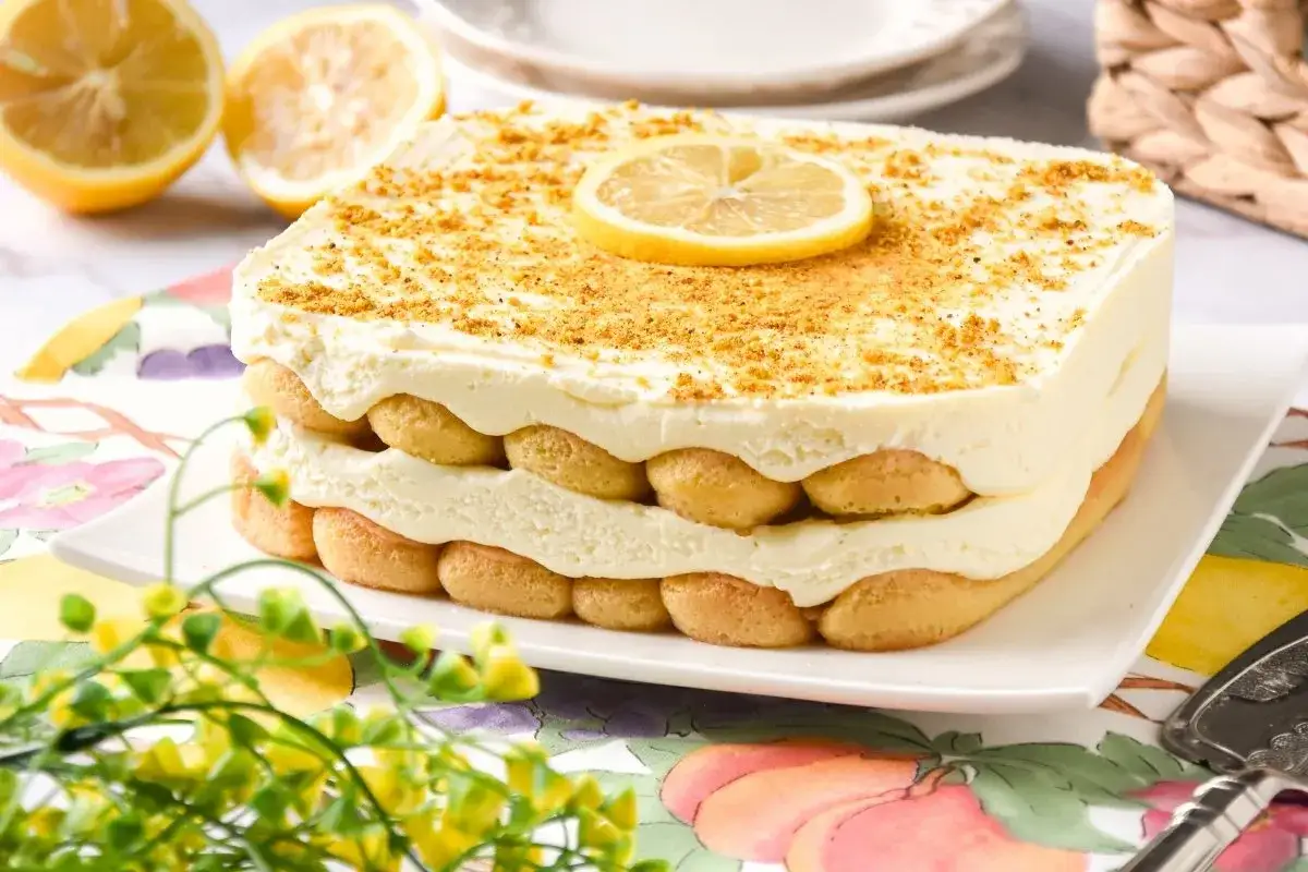 Delicioso tiramisú de limón, con capas de bizcochos de soletilla y crema suave, coronado con ralladura y una rodaja de limón.