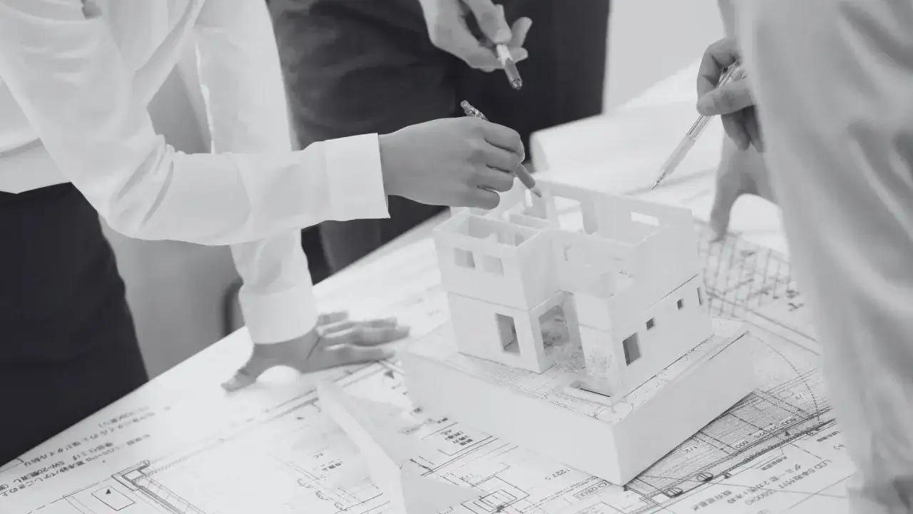 Architekci analizują projekt domu, zastanawiając się, czy samowola budowlana ulega przedawnieniu.