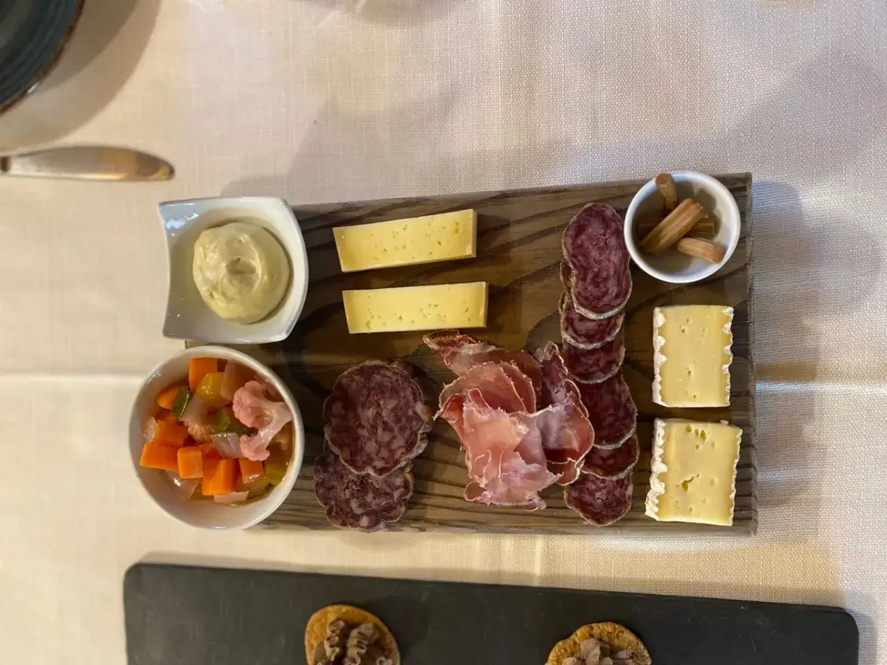 Tagliere con salumi tipici lombardi, formaggi, sottaceti e senape.