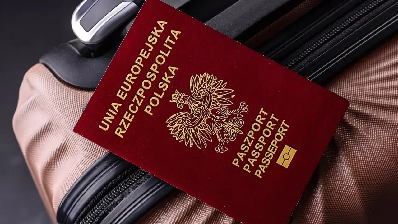 Polski paszport na walizce, gotowy do podróży. Może to być wiza do Londynu, ale dokumenty są kluczowe do każdego wyjazdu.
