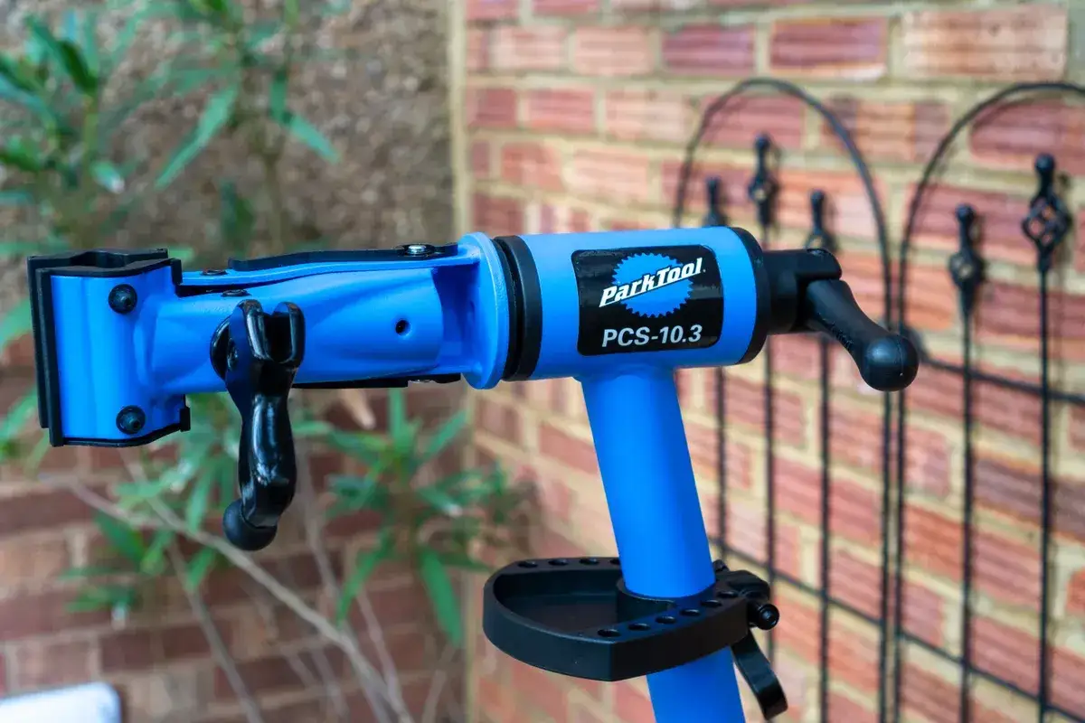A blue Park Tool PCS-10.3 bike repair stand, essential for anyone learning how to build a bike or perform maintenance.
