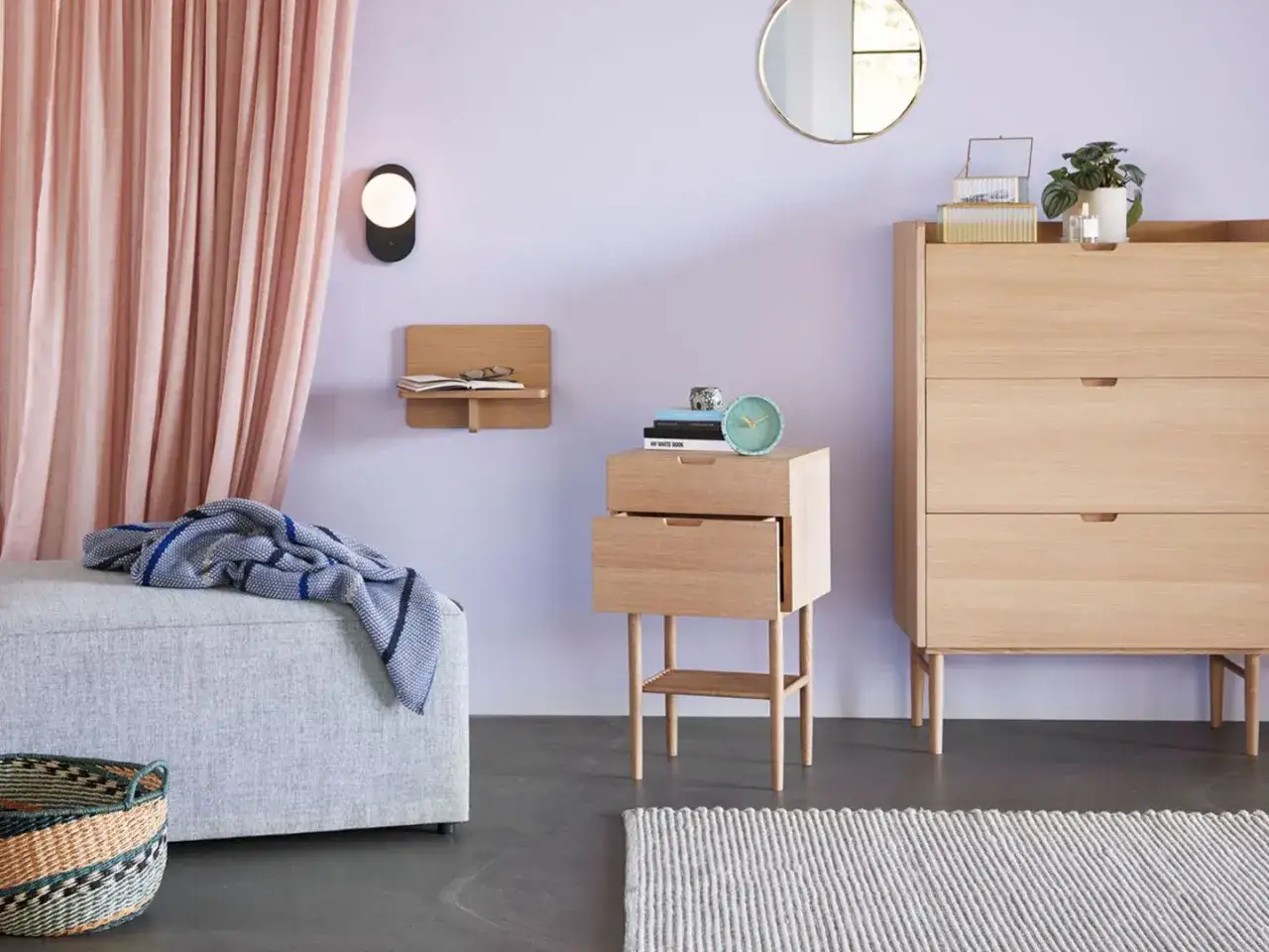 Ein Schlafzimmer mit hellen Holzmöbeln und einer Wand in zartem Lila, das an die Farben erinnert, welche lila ergeben.