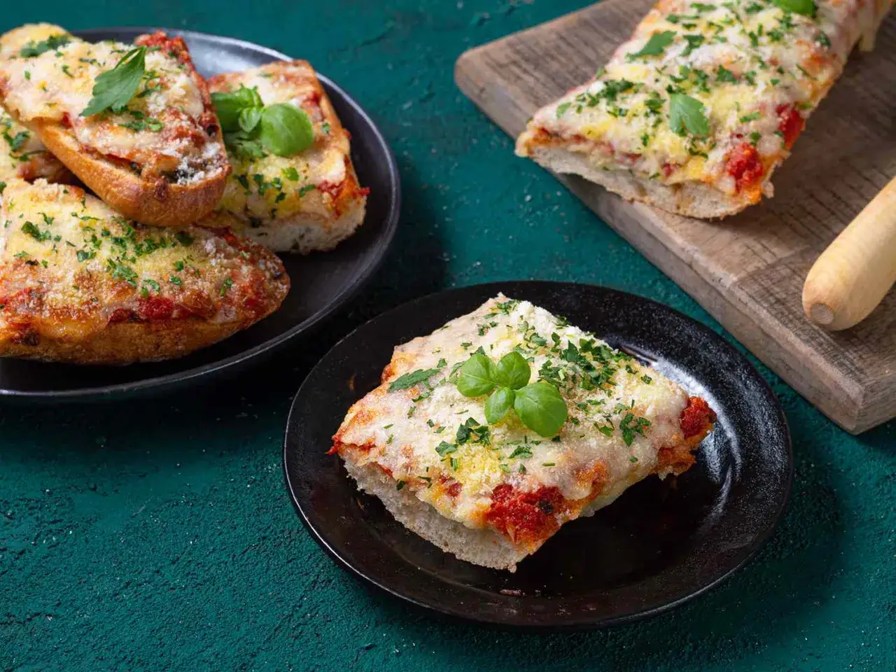 Leckere Bruschetta-Scheiben, belegt mit Tomaten und K&auml;se. Zeigt, was man aus Pizzateig machen kann: knusprige, &uuml;berbackene Brotscheiben.