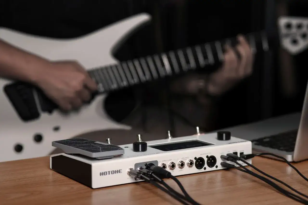 Muzyk gra na gitarze, podłączonej do efektora HOTONE, który jest gotowy do połączenia z PC.