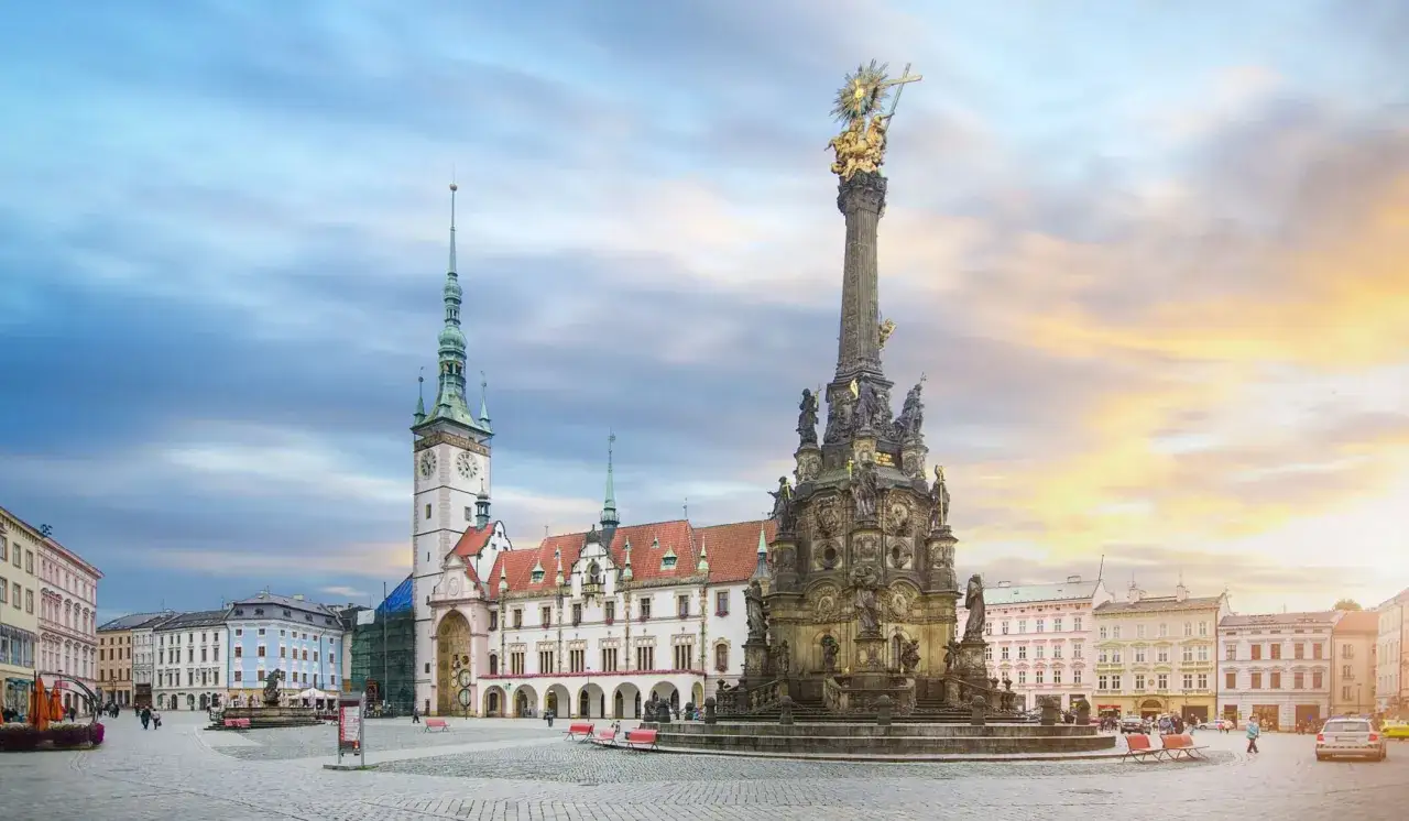 Prachtvoller Platz in Olomouc, Tschechien, mit dem Dreifaltigkeitssäule und dem Rathaus im Abendlicht.