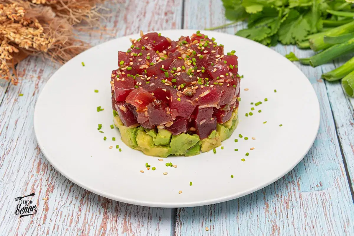 Delicioso tartar de atún fresco con aguacate, espolvoreado con semillas de sésamo y cebollino. ¡Una explosión de sabor!