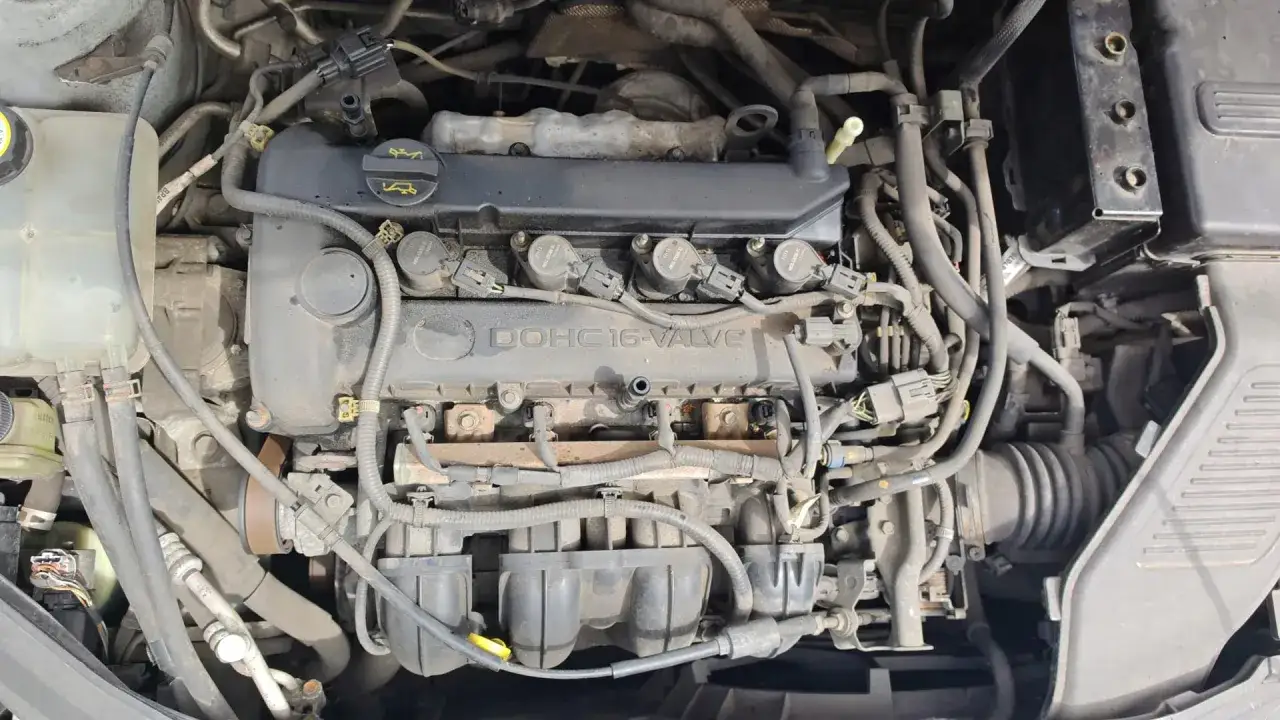 Silnik DOHC 16-zaworowy w Mazda 6 2.0 benzyna. Widoczne cewki zapłonowe, przewody i elementy układu dolotowego.