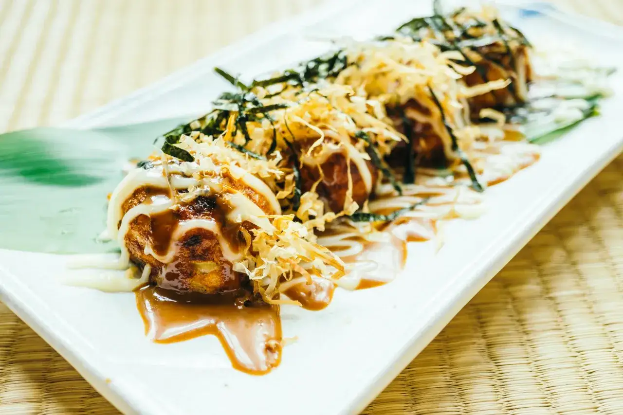 Pyszne takoyaki, idealne do domowego przepisu, polane sosem i majonezem, posypane wi&oacute;rkami bonito i nori.