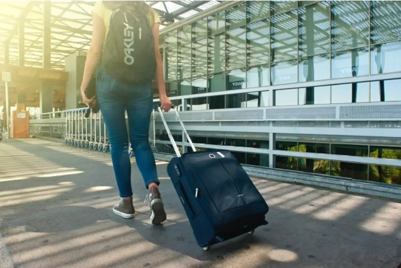 Kobieta z plecakiem Oakley ciągnie walizkę. Czy waga walizki wlicza się do wagi bagażu?