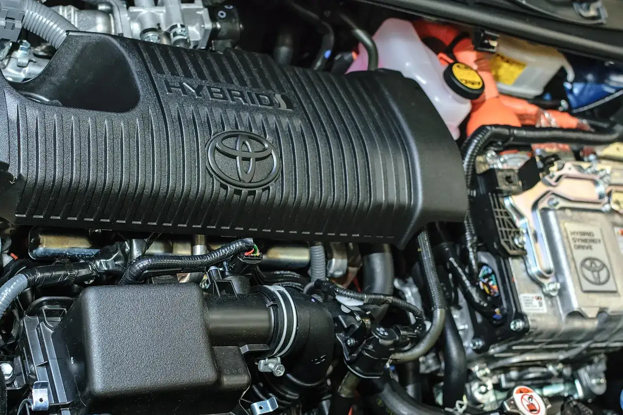 Silnik hybrydowy Toyota z napisem HYBRID i logo Toyoty.