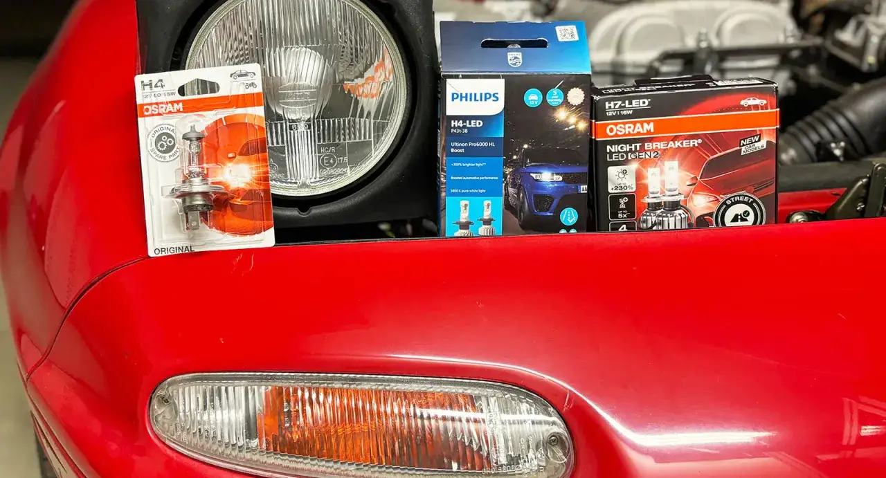 Nya LED-lampor för halvljus från Philips och Osram, redo att byta på en röd bil.