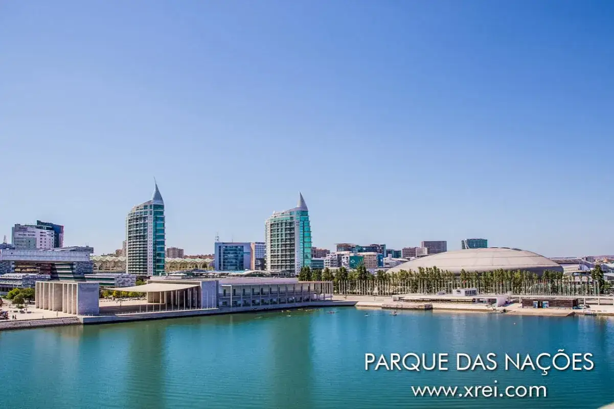 Moderne Architektur am expo gelände lissabon. Ein Wasserkanal spiegelt die Gebäude und den blauen Himmel wider.