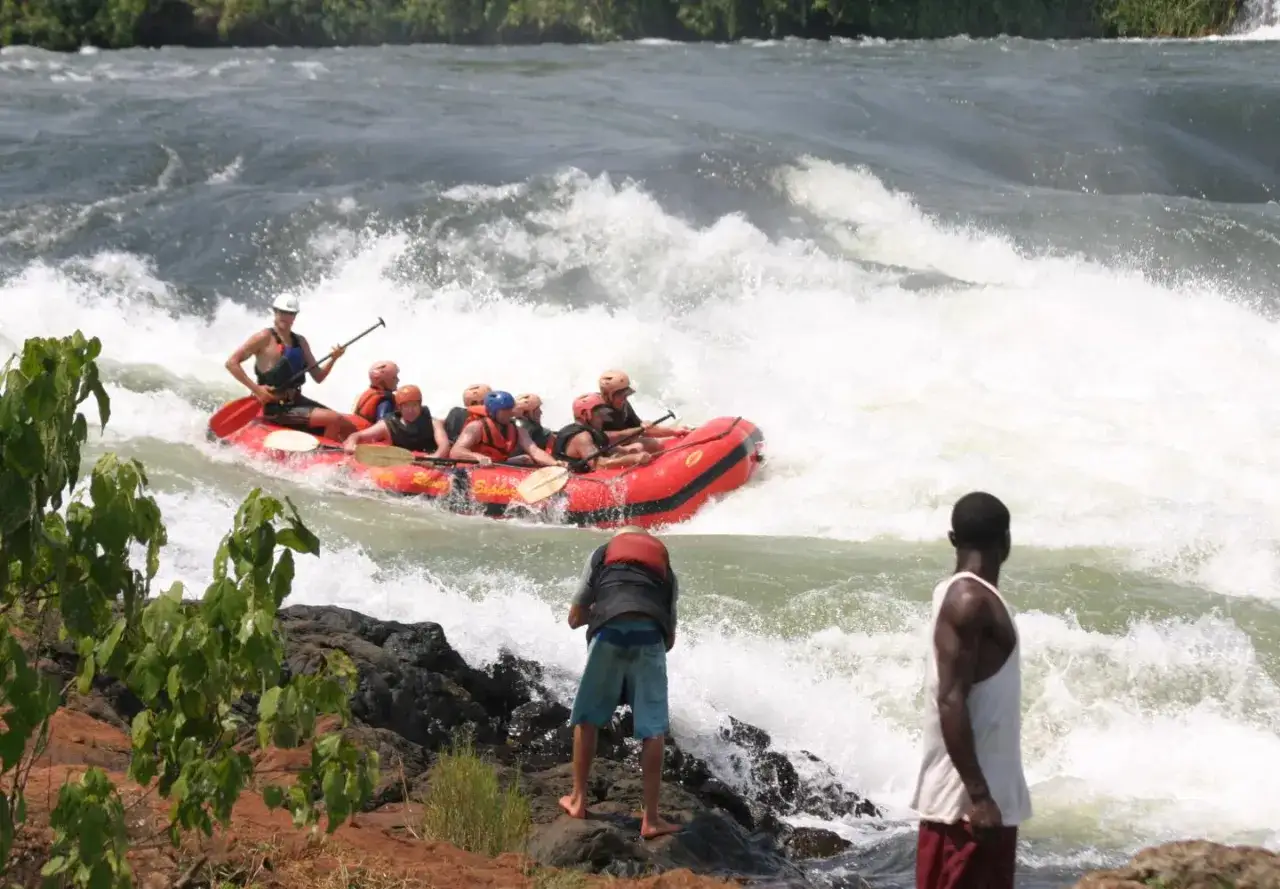 Uganda z czego słynie? Z adrenaliny na Nilu! Grupa turyst&oacute;w na pontonie walczy z rwącym nurtem.