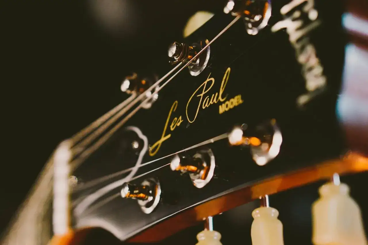 Nahaufnahme des Gitarrenkopfes einer Gibson Les Paul. Die Saiten sind gespannt und bereit für die Gitarrenstimmung.