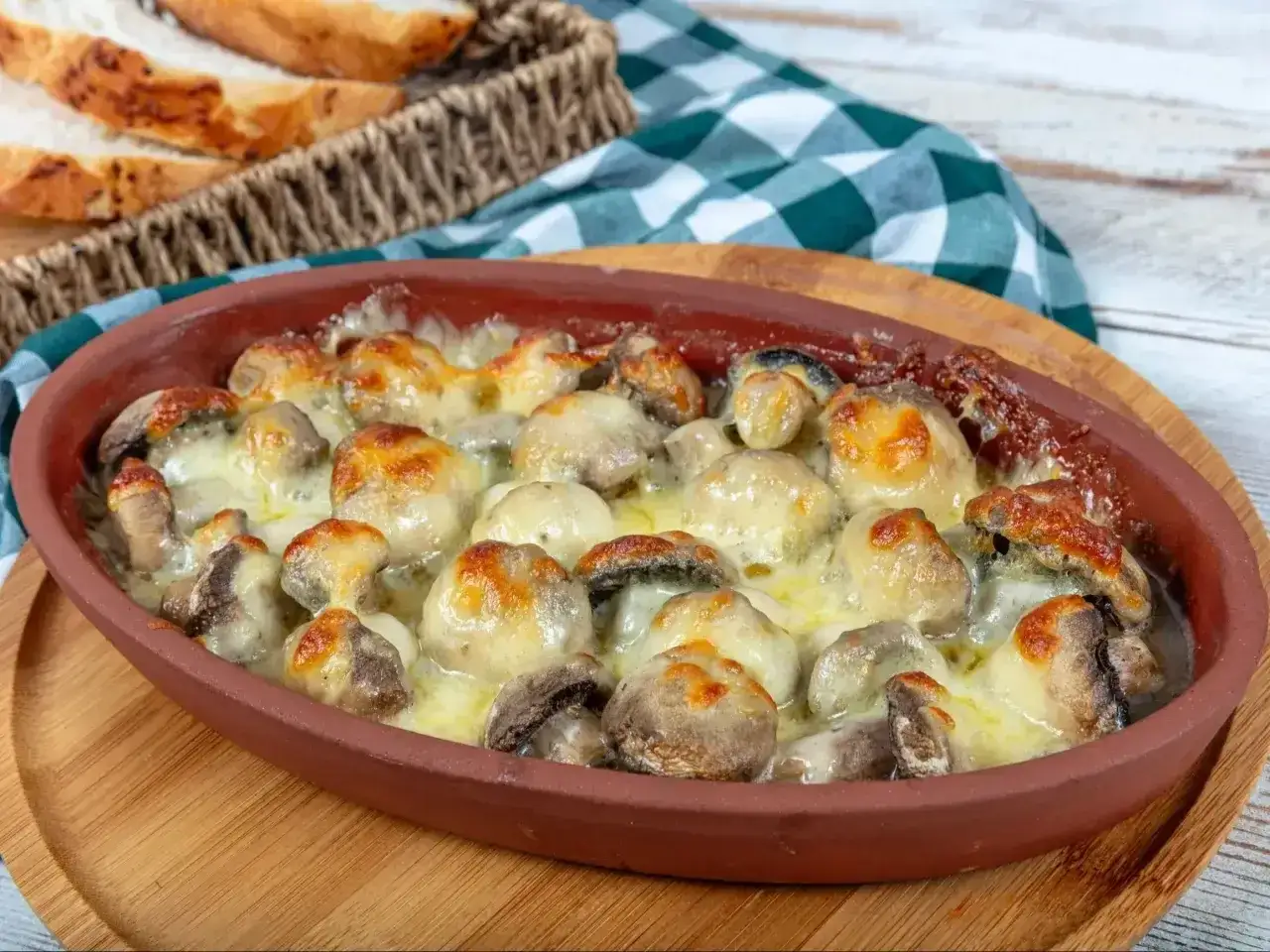 Pyszne pieczarki z piekarnika, zapieczone pod ciągnącym się serem. Idealne jako dodatek do chrupiącego pieczywa.