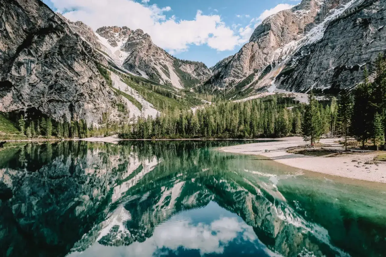 Jezioro w Dolomitach, gdzie odbijają się majestatyczne góry i lasy. To raj dla miłośników przyrody, ukazujący niezwykłe walory przyrodnicze Włoch.